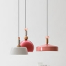 Design-Hängelampe mit Schirm in Pink und Schleife in Kupfer neben Leuchten aus der gleichen Serie